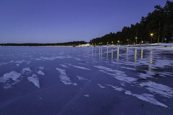 Lac et plage au coucher du soleil avec glace et neige sur la glace — Photo