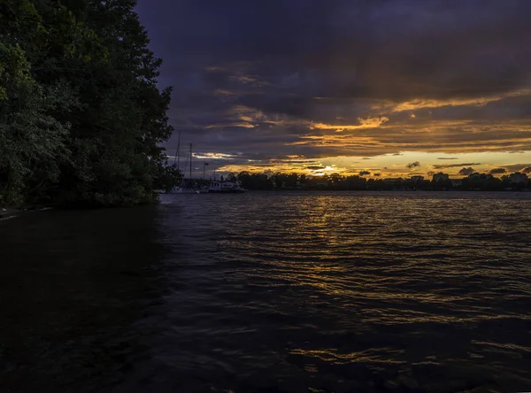 Sonnenuntergang an einem See mit Wald auf der linken Seite — Stockfoto