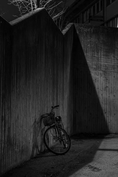 Imagem noite preto e branco de uma bicicleta de frente para uma parede de concreto — Fotografia de Stock