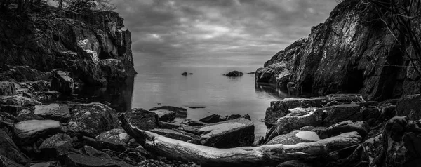 Panoramautsikt över svartvitt strandlinje med klippor — Stockfoto