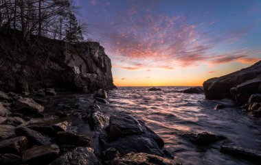 Göl kıyısındaki uçurumlarda ile üzerinde renkli günbatımı