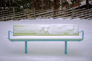 Karla kaplı bir parkbench