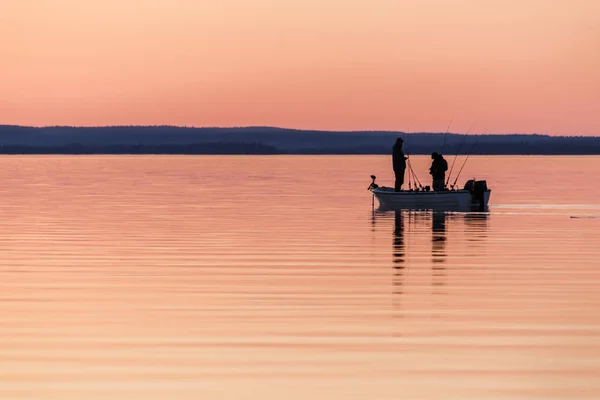 İki kişi küçük tekne günbatımında Balık tutma