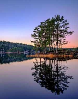 Günbatımı gölde yoktan kar yok bulutlara ile ada