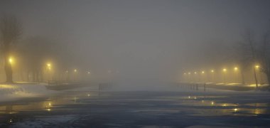 Işıkları parlayan bir deniz önünün kış görüntüsü