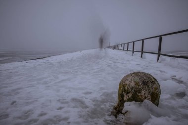 Limanda donmuş bir yolda yürüyen bir hayalet