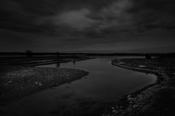 Photo en noir et blanc d'une rivière qui mène à la mer — Photo