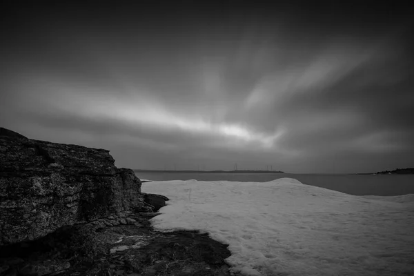 Lunga esposizione immagine di scogliere e neve in riva al mare — Foto Stock