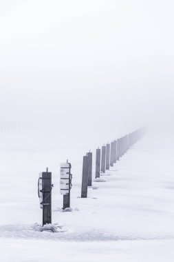 Yığınlar backgroun sis ile donmuş bir göl dışarı sopa