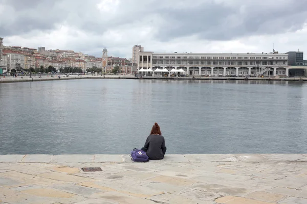 的里雅斯特 2017年9月5日 意大利 一个女孩独自坐在石码头上 — 图库照片