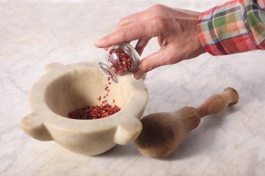 Adamın eli mermer havana pembe tanecikler döküyor. Metnin için de fotokopi alanı var.
