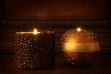 İki yanan mum ahşap bir rafta duruyor. Metnin için fotokopi alanı var.