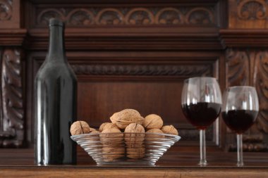 Eski tozlu şarap şişesi ve iştah açıcı yiyeceklerle dolu bir şarap kadehi metin için fotokopi alanı olan ahşap bir rafta dinleniyor.