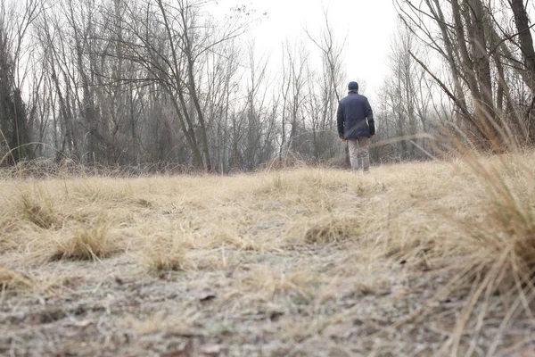 田舎の風景の中を一人で歩いている男の眺め — ストック写真