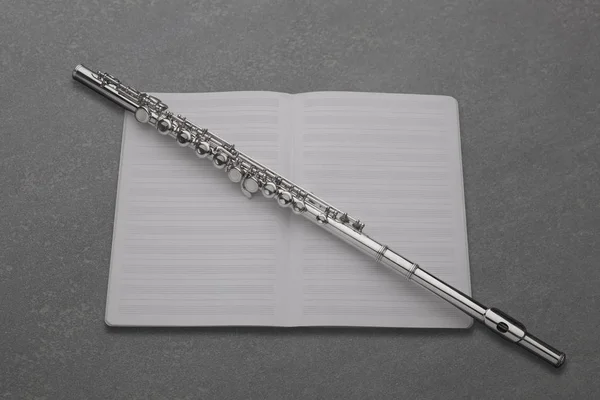 professional transverse flute  and empty music score rest on a slate board with copy space for your text