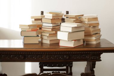 Bir yığın kitap, metin için kopyalama alanı olan ahşap bir masanın üzerinde duruyor.