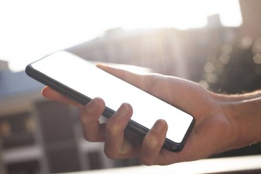 Çocuğun eli ekranda kırpma yolu olan bir cep telefonu tutuyor ve mesajınız için alanı kopyalıyor