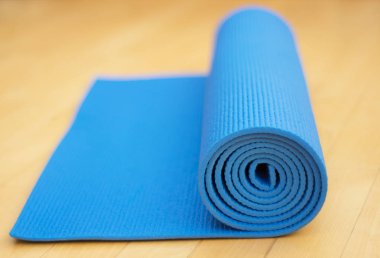 Yoga ve Pilates ahşap zemin üzerinde için haddelenmiş mavi egzersiz minderi