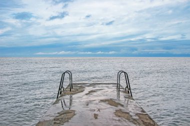 bulutlu gökyüzü ile okyanus iskelede Yüzme