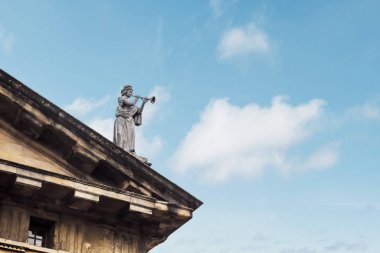 Oxford 'daki Clarendon binasında mavi gökyüzü olan çatıda heykel