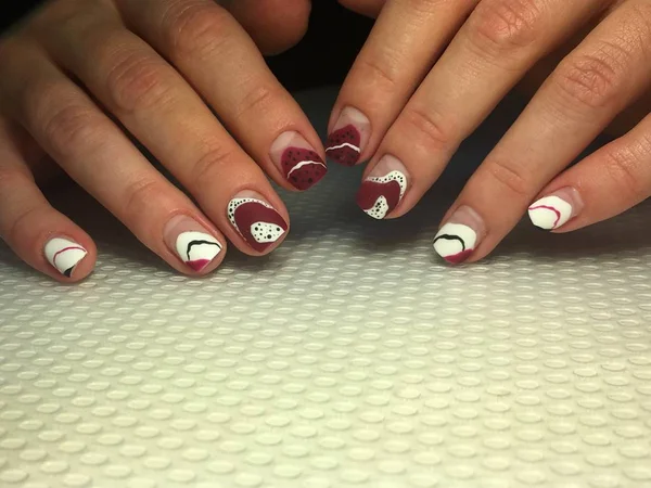 Manicura de moda y elegante con un diseño rojo y puntos blancos —  Fotos de Stock