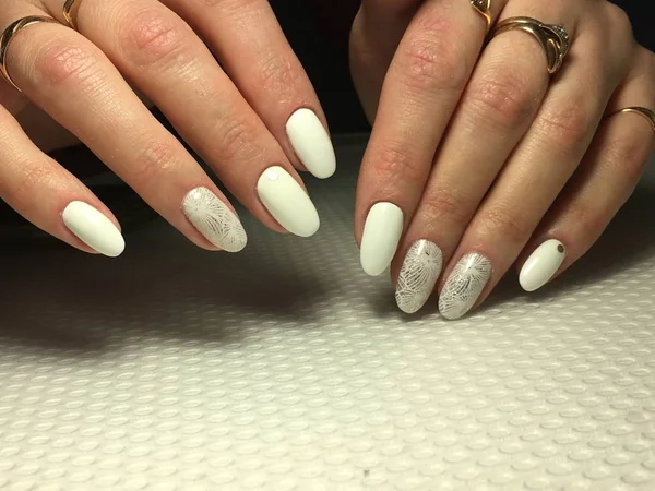Модный белый маникюр с серебряным дизайном на овальных ногтях — стоковое фото