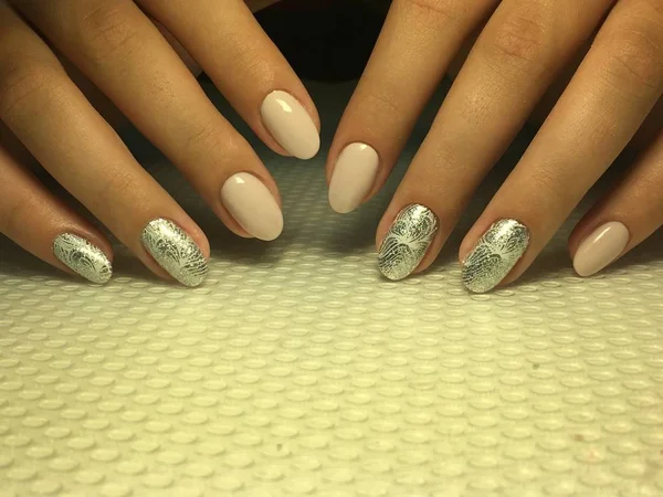 Fashionable beige manicure with silver design on oval nails — Stock Photo, Image