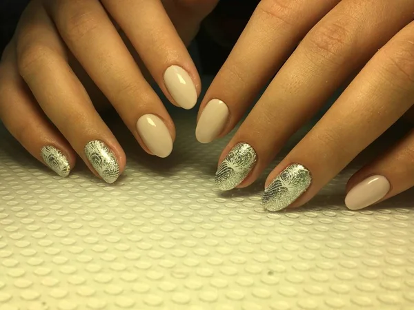Modieuze beige manicure met zilveren design op ovale nagels — Stockfoto