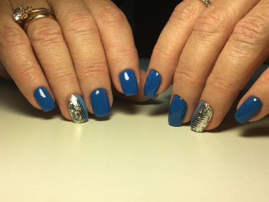 Şenlikli altın desenli şık mavi manikür.