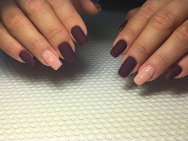 Şenlikli narin bir tasarımı olan şık bir bordo manikür.