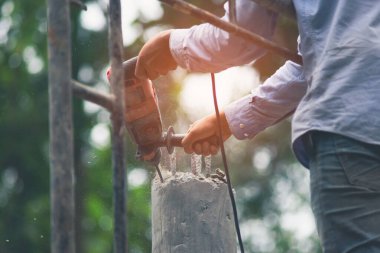 İşçiler beton delmek için darbe matkabı kullanıyorlar. Güneş ışığı altında