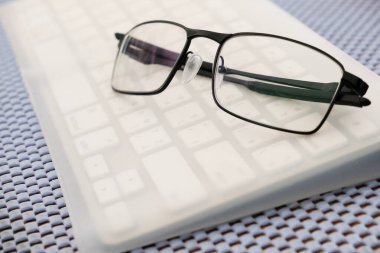 Masadaki bilgisayar klavyesine gözlük takıldı.