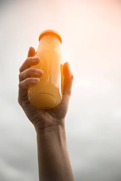 Sap in fles in de hand van de vrouw — Stockfoto