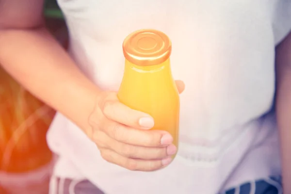 Сок в бутылке в руке женщины — стоковое фото