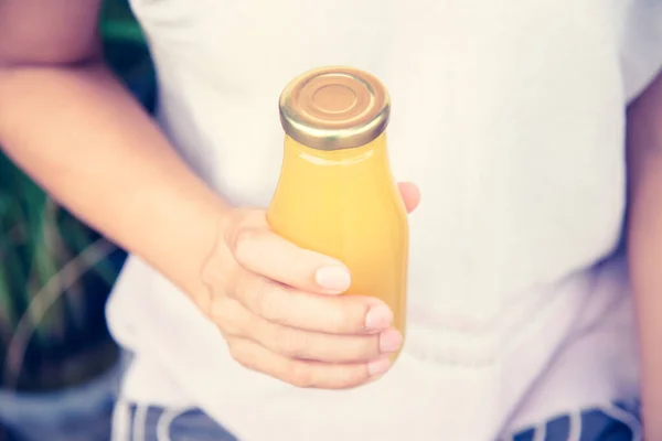 Сок в бутылке в руке женщины — стоковое фото