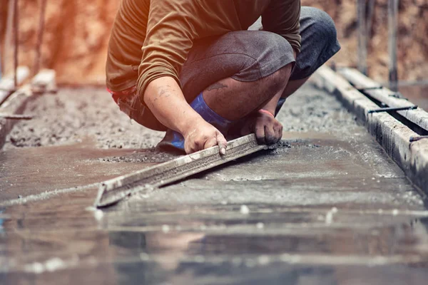 Arbetarna justerar betongytan smidigt. — Stockfoto