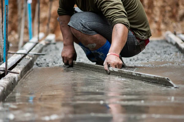 Arbetarna justerar betongytan smidigt. — Stockfoto