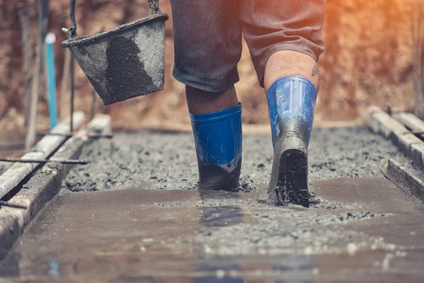 Pracownicy chodzą po betonie, który jest nadal płynny. — Zdjęcie stockowe