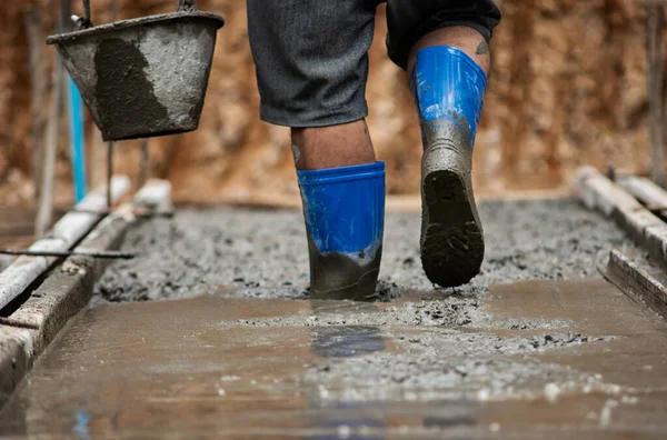 Pracownicy chodzą po betonie, który jest nadal płynny. — Zdjęcie stockowe