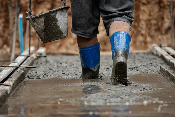 Pracownicy chodzą po betonie, który jest nadal płynny. — Zdjęcie stockowe