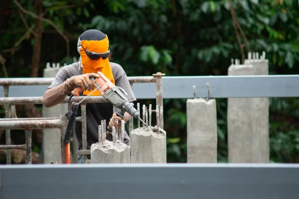 Pracownicy używają wiertarki udarowej do wiercenia betonu. — Zdjęcie stockowe