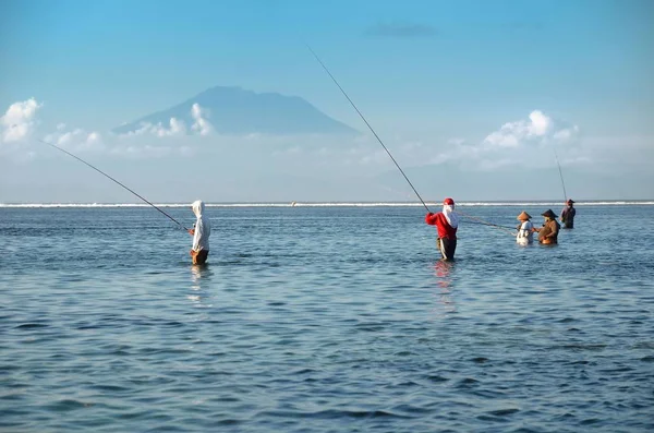 Traditionella balinesiska fiskare står i grunt vatten vid lågvatten på stranden i Nusa Dua — Stockfoto