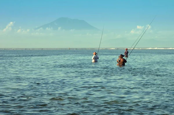 Traditionella balinesiska fiskare står i grunt vatten vid lågvatten på stranden i Nusa Dua — Stockfoto