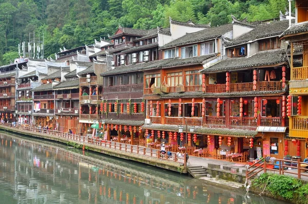 Fenghuang, China - 15 de mayo de 2017: Gente en el patio de comidas a orillas del río cerca del puente Phoenix Hong en Fenghuang — Foto de Stock