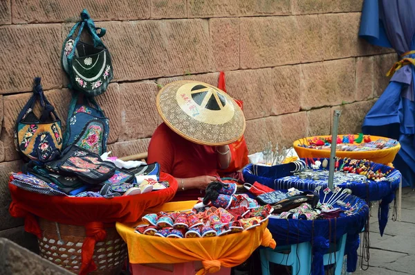 China woman selling souvenirs on market in Fenghuang