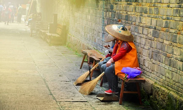 Fenghuang, China - 15 de mayo de 2017: La mujer descansa en la calle en la ciudad de Phoenix Fenghuang — Foto de Stock