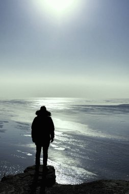 Sun, Yalnız gezgin kavramı seyir kışın yüksek bir uçurumun kenarında kalan bir adam silüeti