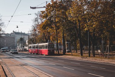 Viyana, Avusturya - Ekim 2019: Viyana 'da sonbahar sezonunda kırmızı tramvay ve araba trafiği geniş yol