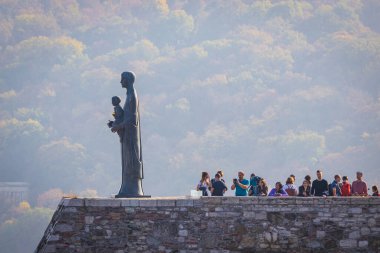 BUDAPEST, HUNGARY - Ekim 2019: Macaristan 'ın başkenti Budapeşte' deki Royal Palace 'ta Bakire Meryem heykelinin yanındaki turistler