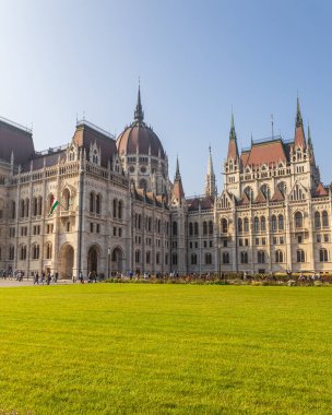 Macaristan Parlamentosu 'nun ünlü binası ve yeşil çimenliği güneşli bir günde, Budapeşte şehrinde
